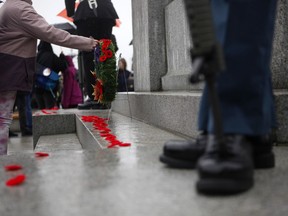 Organizers say Remembrance Day services will be held rain or shine across British Columbia's south coast tomorrow, but wild weather may test the resolve of attendees. People take part in a Remembrance Day service at the cenotaph on the grounds of the legislature in Victoria, Thursday, Nov. 11, 2021.