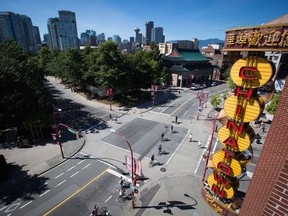 Cyclists ride past a neon Chinatown sign in Vancouver, B.C., on Thursday Aug. 18, 2016. A man accused of stabbing three people lost his bid to seal a document that identified him as a "significant threat" before he was release from a forensic psychiatric hospital.