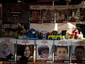 Posters of children held hostage by Hamas in the Gaza Strip are displayed with toys across from the Kirya, headquarters of Israel's Defense Forces ahead of an anticipated hostage release, in Tel Aviv, Israel, Thursday, Nov. 23, 2023.