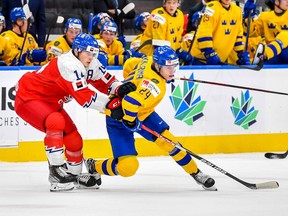 Stanislav Svozil of Czechia and Jonathan Lekkerimaki of Sweden keep their eyes on the play during the 2022 IIHF World Junior Championship bronze medal game at Rogers Place on August 20, 2022 in Edmonton.