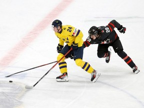 Sweden's Tom Willander (left) and Canada's Conor Geekie vie for the puck during the Group A ice hockey match between Canada and Sweden of the IIHF World Junior Championship in Gothenburg, Sweden on Dec. 29, 2023.