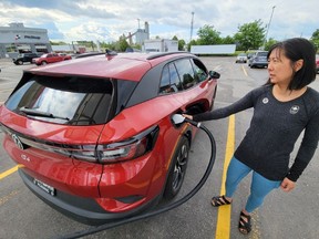 A woman checks the status of the charge for her 2022 Volkswagen ID.4 EV at a Toronto-area charging station. Searches for electric vehicles account for less than three per cent of overall searches on AutoTrader in 2023.