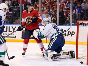 Florida Panthers center Sam Reinhart (13) watches as the puck gets past Vancouver Canucks goaltender Thatcher Demko (35) on a goal scored.by left wing Jonathan Huberdeau during the second period of an NHL hockey game, Tuesday, Jan. 11, 2022, in Sunrise, Fla.