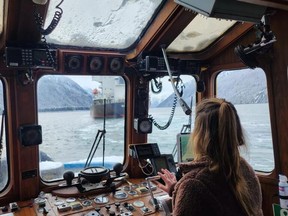 A woman tugboat captain works the controls in B.C. ocean waters.