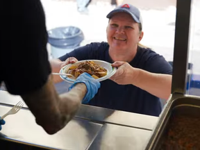 Cristien Donhuysen passes out free community meals from FIRST UNITED’s food truck, which averages more than 250 meals during its daily lunch service on weekdays. SUPPLIED by Grey Coast Film