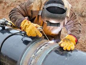 A welder installs a gas pipeline.