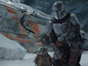 Pedro Pascal with Grogu (a.k.a. Baby Yoda) in an episode of The Mandalorian.