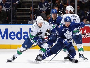 Andrei Kuzmenko checks Mitchell Marner of the Maple Leafs during a game last November in Toronto.