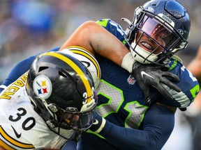 Devon Witherspoon of the Seattle Seahawks tackles Jaylen Warren of the Pittsburgh Steelers during the third quarter at Lumen Field on Dec. 31, 2023 in Seattle, Washington.