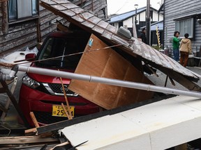 A car covered with debris from a house in Wajima, Ishikawa prefecture on Jan. 6. Focus has turned to recovering bodies rather than finding survivors, but an elderly woman was rescued Saturday.