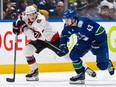 Senators centre Ridly Greig keeps an eye on Canucks captain Quinn Hughes on Tuesday at Rogers Arena.