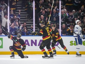 Vancouver Canucks' Conor Garland, Nikita Zadorov and Teddy Blueger celebrate Garland's goal as Toronto Maple Leafs' T.J. Brodie looks on during the first period of an NHL game in Vancouver, on Saturday, January 20, 2024.