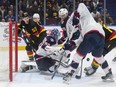 Columbus Blue Jackets goalie Elvis Merzlikins stops Vancouver Canucks' Dakota Joshua, back right, as Teddy Blueger and Columbus' Yegor Chinakhov watch during the first period of an NHL game in Vancouver January 27, 2024.