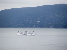 The B.C. Ferries vessel Queen of Surrey passes Bowen Island while traveling on Howe Sound from Horseshoe Bay to Langdale, B.C., on Friday, April 23, 2021. BC Ferries has awarded a contract to build four new hybrid-electric vessels to be ready to sail by 2027.