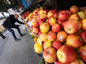 A man buys apples at a produce stand in Vancouver.