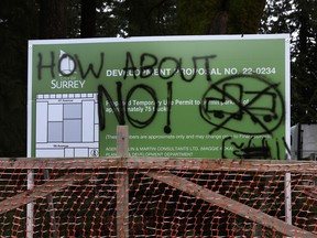 Graffiti on a sign protesting truck parking and industrial development in Surrey.