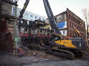 Debris falls to the ground as demolition resumes on the Winters Hotel after a body was found in the single room occupancy (SRO) building, in Vancouver, B.C., Friday, April 22, 2022.