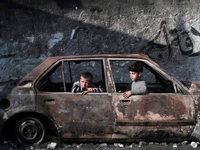 Children sit in a destroyed car in Rafah, on the southern Gaza Strip on Feb. 28, 2024, amid ongoing battles between Israel and the Palestinian militant group Hamas.