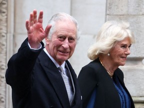 King Charles III waves as he leaves the London Clinic with Queen Camilla on January 29, 2024.