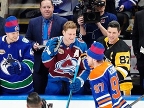 Elias Pettersson (left) congratulates Connor McDavid (centre) for winning the NHL All-Star skills competition on Friday. McDavid would later snub the Canucks in the podcast room.