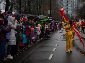 People watch the 50th Annual Spring Festival Parade through Chinatown in Vancouver on Sunday.