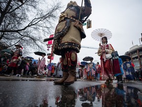 People walk down the street while wearing traditional clothing during the 50th annual Spring Festival Parade for the Lunar New Year in Vancouver, B.C., Sunday, Feb. 11, 2024.