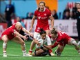 Canada's Krissy Scurfield (right) takes down New Zealand's Risi Pouri-Lane as Canada's Olivia Apps (left) and Caroline Crossley watch during Vancouver Sevens women's rugby semifinal action, in Vancouver, on Sunday, Feb. 25, 2024.