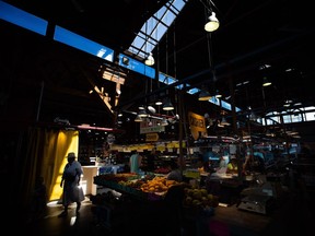 A new report ahead of next week's B.C. budget is forecasting slower economic growth for the province this year. A person is silhouetted as people shop for produce at the Granville Island Market in Vancouver, on Wednesday, July 20, 2022.