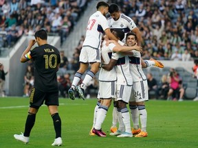 The Vancouver Whitecaps celebrate after defender Ranko Veselinovic scored during an MLS match against Los Angeles FC in L.A. on June 24, 2023.