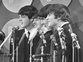 FILE - The Beatles address the media in the press room of Kennedy International Airport on their arrival, Feb. 7, 1964 in New York. The Beatles are getting the big-screen biopic treatment in not just one but a Fab Four of movies that will give each band member their own film, all of which are to be directed by Sam Mendes.