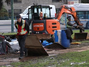 Provincial workers clean up after most residents left a temporary homeless camp