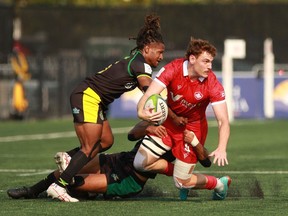 Team Canada's Phil Berna looks for an open player as he's tackled by Team Jamaica's Nic Franklyn during men's rugby action at the Rugby Sevens Paris 2024 Olympic qualification event at Starlight Stadium in Langford on Aug. 19, 2023.