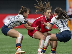 Spain's Jimena Blanco-Hortiguera Pedrero, left, and Spain's Anne Fernandez de Corres, right, try to take down Canada's Chloe Daniels during Vancouver Sevens in Vancouver Feb. 24, 2024.