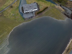 In this photograph taken with a drone; a large amount of water floods a low area of a farm near a house in Abbotsford, B.C., Wednesday, Jan. 31, 2024. A bulletin from B.C.'s River Forecast Centre says rainfall since Friday has ranged from 70 to more than 500 millimetres across the South Coast, while unseasonable warmth has added between 75 and 150 millimetres of snowmelt in recent days.