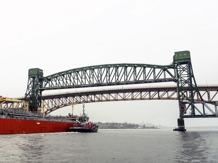  The tugboat HaiSea Wamis escorts a tanker in the Second Narrows last fall. It is about to travel under two key bridges, a railway bridge (foreground) and the Ironworkers Memorial highway bridge (background).