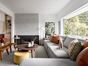 A large L-shaped sectional sofa sits comfortably in the small space, maximize seating with an integrated side table, while large Ottomans do double duty as side tables and extra chairs. Vintage bent-wood Eames chairs were the homeowners' own.