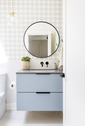 A small powder room on the main floor received an upgrade with a new shower lined in soft grey glazed tile, and a space-saving custom concrete floating sink.