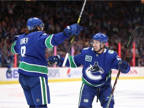 Canucks defenceman Chris Tanev celebrates his goal with D-man Quinn Hughes during an 8-2 romp over the Kings on Oct. 9, 2019, at Rogers Arena.