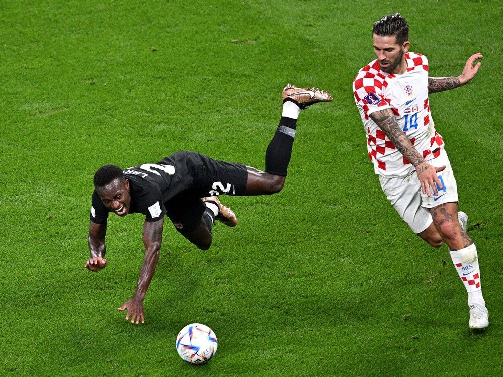 Ричи Ларья из Канады борется за владение мячом с Марко Ливая из Хорватии во время матча группы F чемпионата мира по футболу FIFA 2022 в Катаре между Хорватией и Канадой на Международном стадионе Халифа 27 ноября 2022 года в Дохе, Катар.