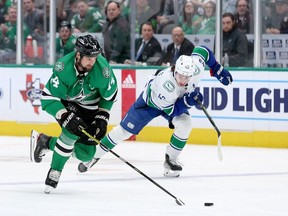 Stars captain Jamie Benn eludes Quinn Hughes before scoring during a 5-4 Canucks overtime victory Feb. 27, 2023 in Dallas.