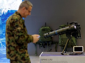 A member of the Swiss army walks past an Israeli-made Spike LR2 Long-Range Missile on March 21, 2024. A version of the Spike LR2 was recently fast-tracked by Canada for its troops in Latvia.