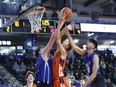 Ryder Vanderkooi of Unity Christian goes up for a shot against Temo Laughlin and Loay Almahmiid of the Gidgalang Kuuyas Naay Breakers in Single A boys basketball provincial championship action on Saturday at the Langley Events Centre.