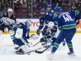 Vancouver Canucks goalie Thatcher Demko, front left, stops Winnipeg Jets' Cole Perfetti (91) as Vancouver's Elias Pettersson (40), Filip Hronek (17) and Winnipeg's Sean Monahan, back left, watch during the second period of an NHL hockey game in Vancouver, on Saturday, Feb. 17, 2024.