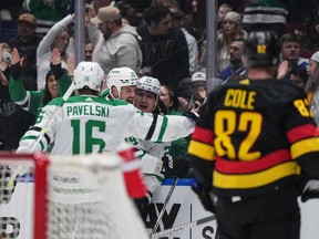 Dallas Stars' Roope Hintz (24), Jamie Benn (14) and Joe Pavelski (16) celebrate Hintz's goal as Vancouver Canucks' Ian Cole (82) watches during the first period of an NHL hockey game in Vancouver, on Thursday, March 28, 2024.