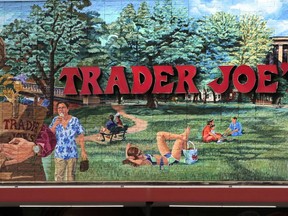 FILE - The Trader Joe's logo hangs on a mural, Aug. 13, 2019, in Cambridge, Mass. Trader Joe's recently upped the price to 23 cents for a single banana, marking a 4-cent increase from the grocer's previous going rate for the fruit that remained unchanged for over 20 years.