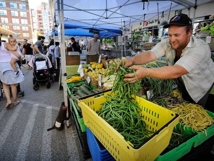  Brett Lawton pours out fresh green beans at the Yaletown Farmers Market in Vancouver in a file photograph.