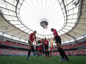 Youth soccer players kick a ball around on the field at B.C. Place stadium during a gathering to watch Vancouver be chosen as one of the host cities for the 2026 FIFA World Cup, in Vancouver, on Thursday, June 16, 2022.The city of Vancouver says it's unable to give a complete estimate of costs associated with hosting 2026 FIFA World Cup matches, due to hosting two more games than originally anticipated.THE CANADIAN PRESS/Darryl Dyck