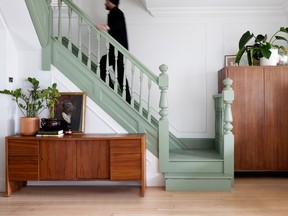 The house's original bannister and stairs were restored and refreshed with a soft neutral green.