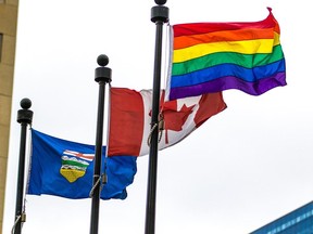 The Pride flag flies with the Canadian and Alberta flags after a flag raising to celebrate Pride Week outside the McDougall Centre in Calgary on Monday Aug. 27, 2013.
