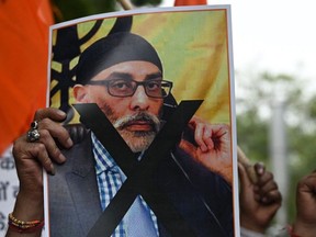 A member of United Hindu Front organization holds a banner depicting Gurpatwant Singh Pannun, a lawyer believed to be based in Canada designated as a Khalistani terrorist by the Indian authorities, during a rally in New Delhi on Sept. 24, 2023.